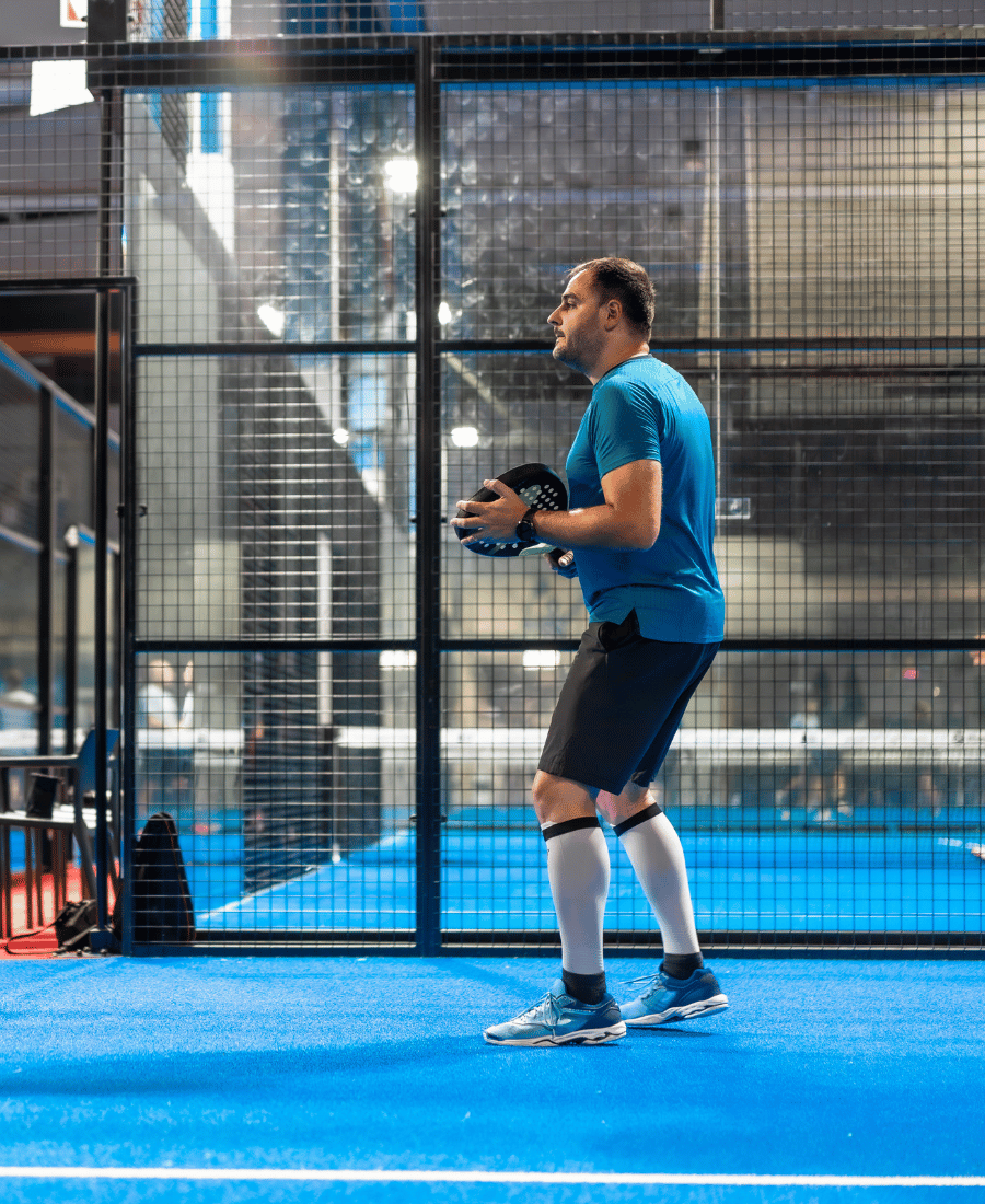 Mature Man Playing Paddle in an Indoor Public Court